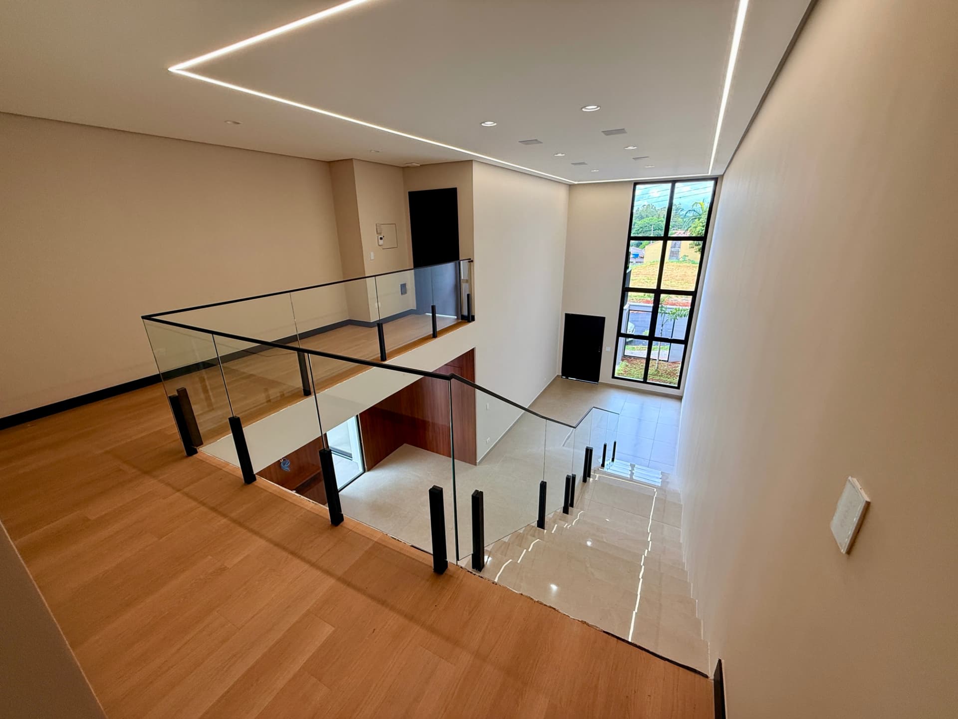 Mezanino com guarda-corpo de vidro da Casa 433